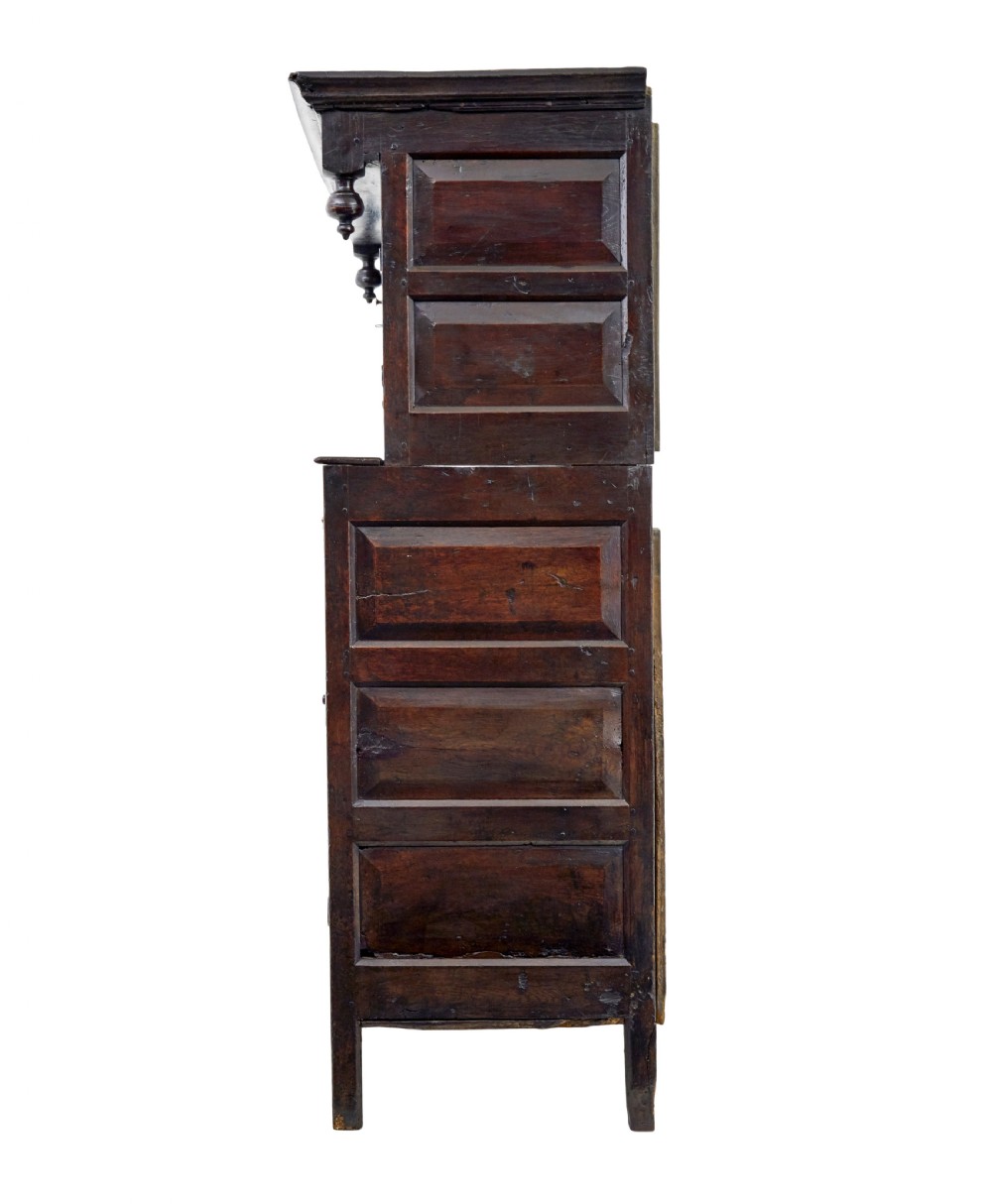 A seventeenth-century dark oak Welsh court cupboard featuring raised geometric panels, turned pendant drops, small central drawers, and double lower doors. View VIII