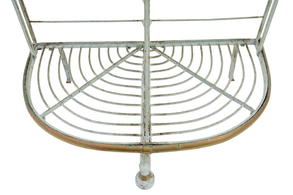 An early twentieth-century French pale blue painted wrought iron bakers rack with decorative scrollwork cresting and brass edging. View V