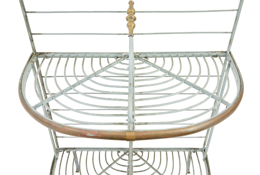 An early twentieth-century French pale blue painted wrought iron bakers rack with decorative scrollwork cresting and brass edging. View VI