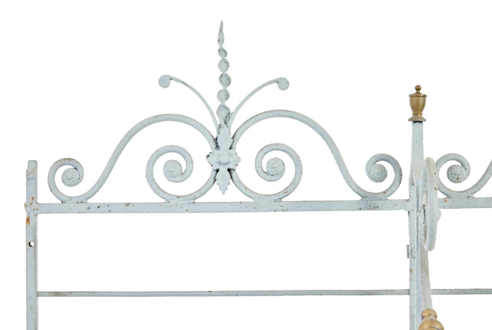 An early twentieth-century French pale blue painted wrought iron bakers rack with decorative scrollwork cresting and brass edging. View VII