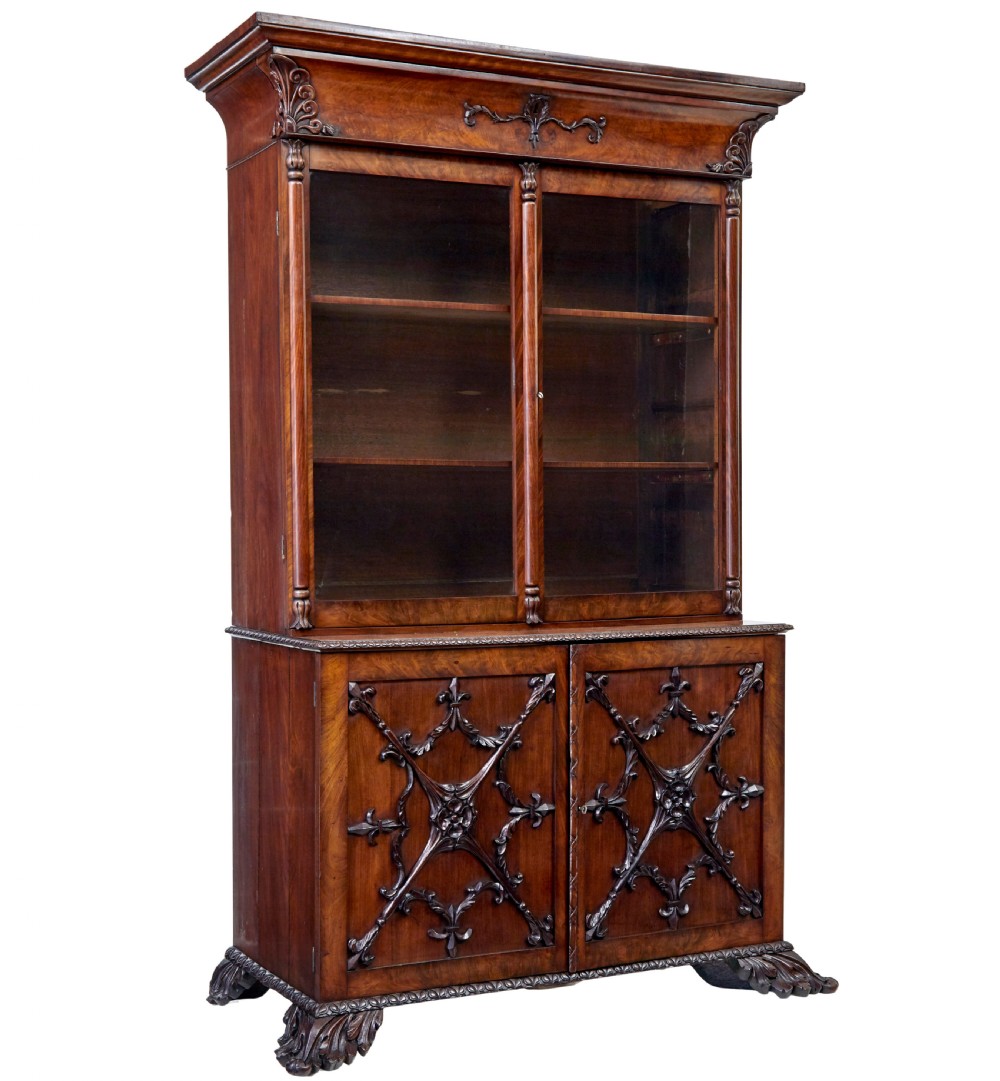 A mid-19th century Danish mahogany bookcase featuring a glazed upper display cabinet and lower doors with elaborate relief carvings.