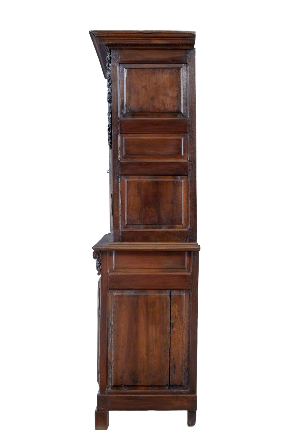 An eighteenth-century French carved walnut cupboard in two tiers featuring geometric relief panels, floral motifs, cherub carvings, and decorative steel hinges. View III