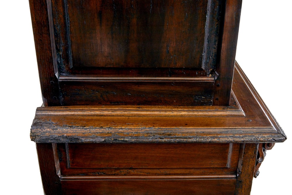 An eighteenth-century French carved walnut cupboard in two tiers featuring geometric relief panels, floral motifs, cherub carvings, and decorative steel hinges. View VI