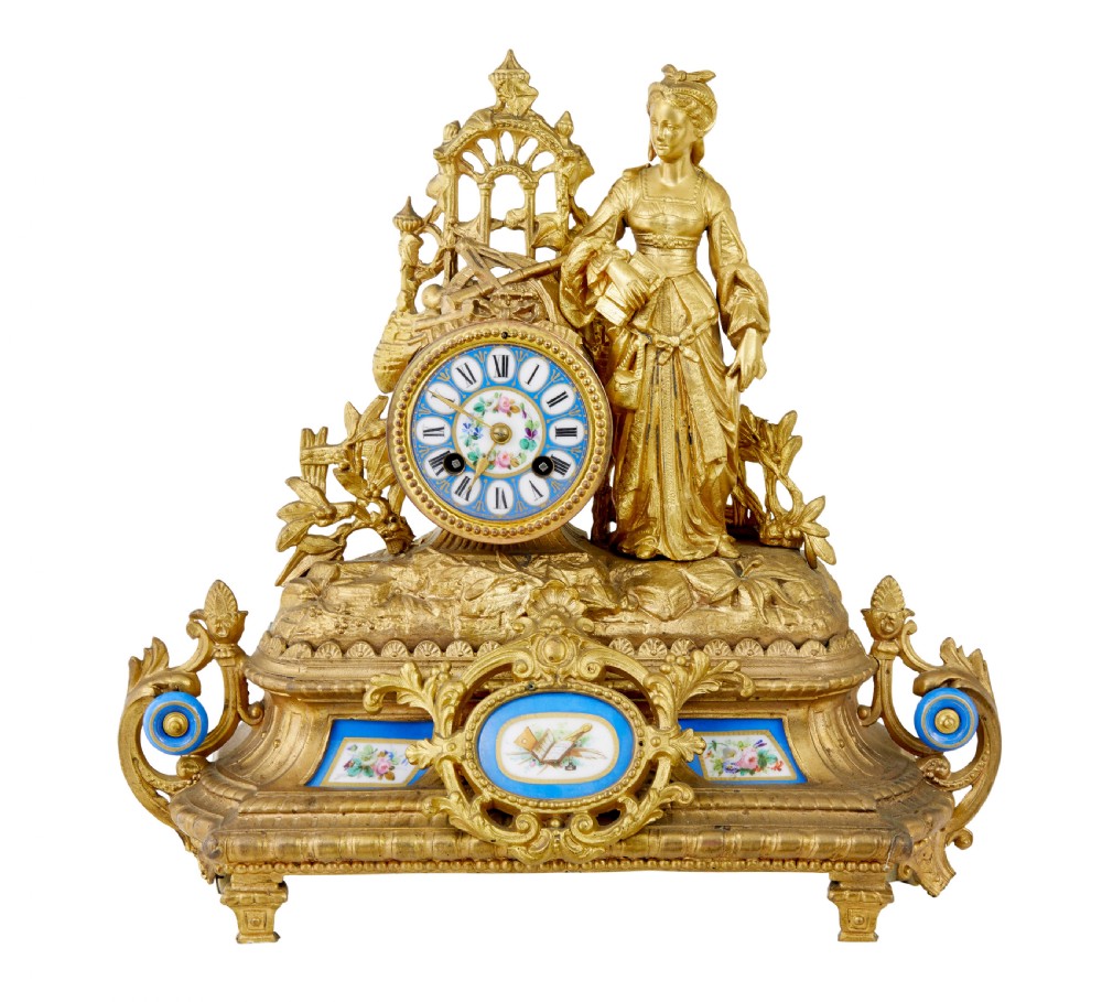 An ornate 19th-century French gilt metal mantel clock featuring a sculpted female figure, Rococo scrollwork, and hand-painted turquoise blue porcelain plaques.