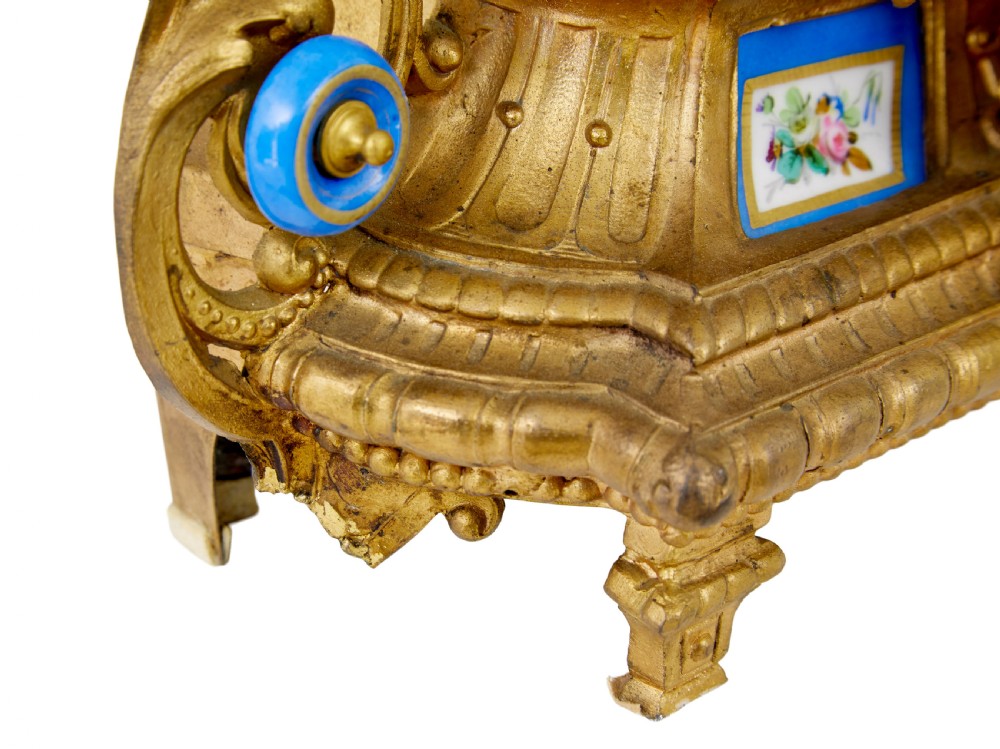 An ornate 19th-century French gilt metal mantel clock featuring a sculpted female figure, Rococo scrollwork, and hand-painted turquoise blue porcelain plaques. View VI
