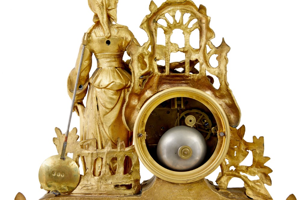 An ornate 19th-century French gilt metal mantel clock featuring a sculpted female figure, Rococo scrollwork, and hand-painted turquoise blue porcelain plaques. View IX