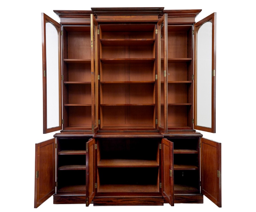 A large early Victorian flame mahogany breakfront bookcase featuring glazed upper doors and panelled lower cupboard doors. View II