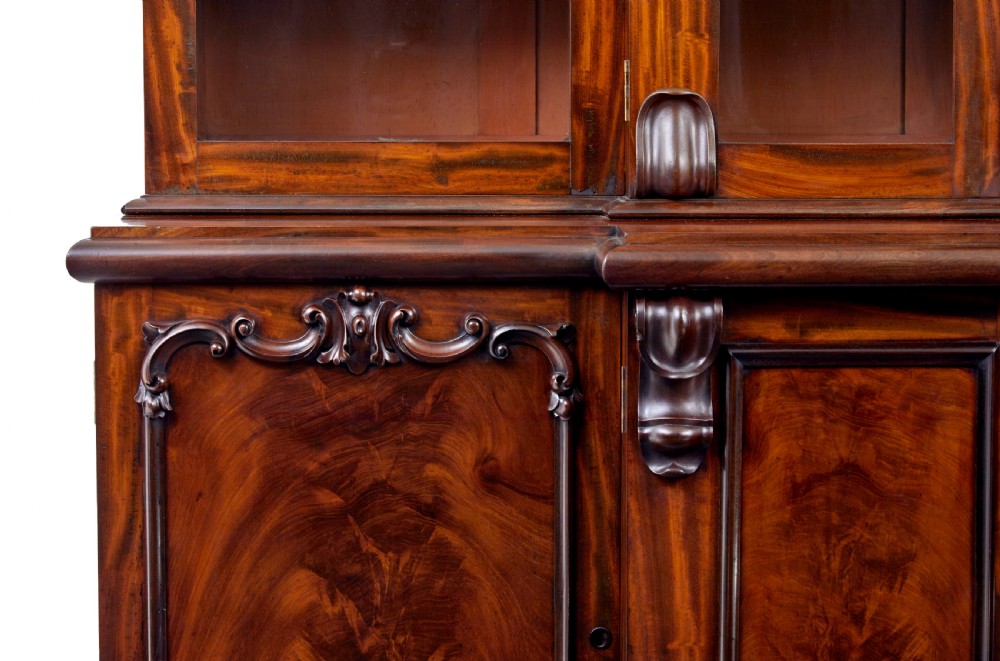 A large early Victorian flame mahogany breakfront bookcase featuring glazed upper doors and panelled lower cupboard doors. View III