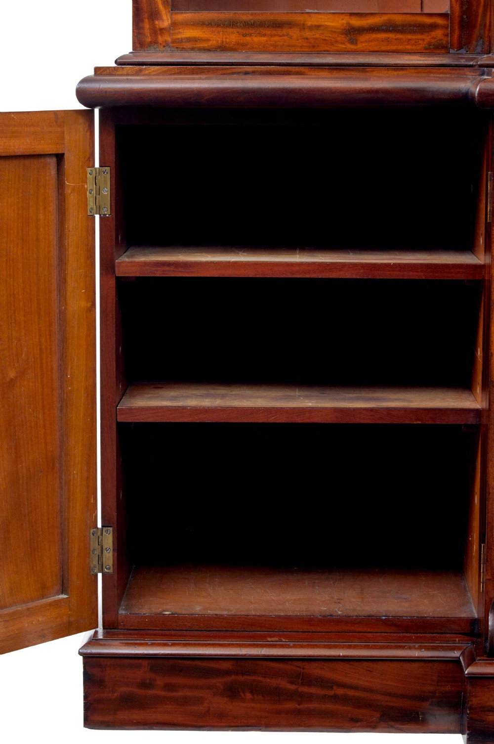 A large early Victorian flame mahogany breakfront bookcase featuring glazed upper doors and panelled lower cupboard doors. View V