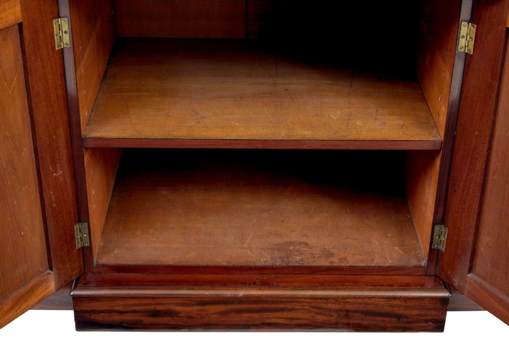 A large early Victorian flame mahogany breakfront bookcase featuring glazed upper doors and panelled lower cupboard doors. View XI