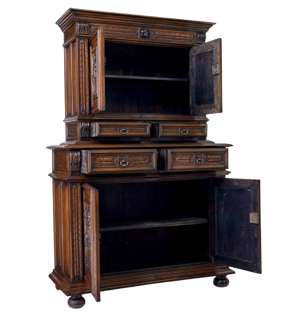 Mid 19th century dark walnut two-tiered Italian cabinet featuring intricately carved relief panels of figures, decorative drawers, and bun feet. View III