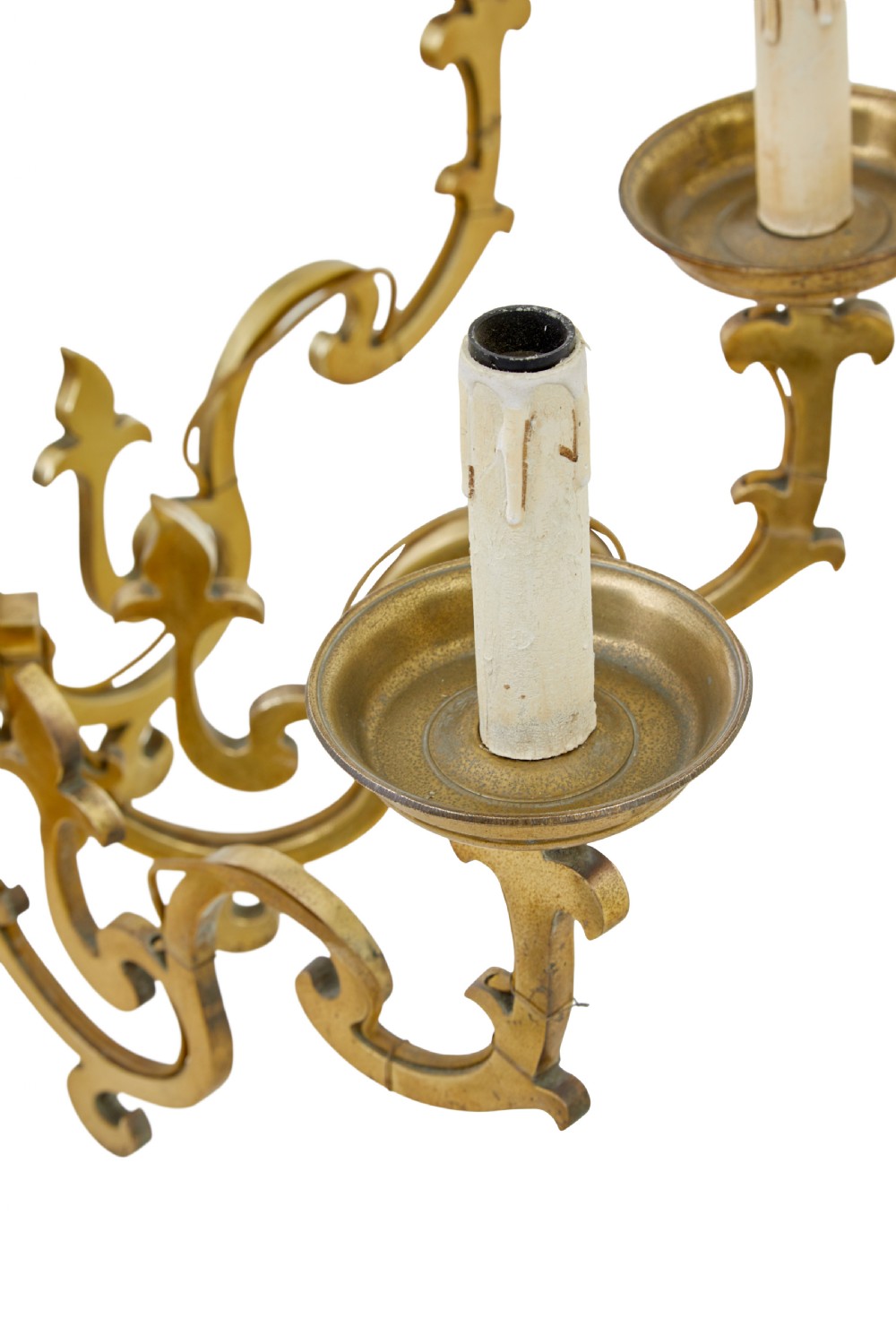 An early 20th century brass eight-arm chandelier featuring scrolling branches, circular drip pans, candle sleeves, a central baluster stem, and a suspension chain. View V