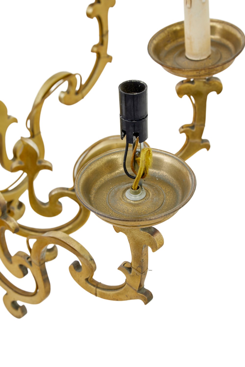 An early 20th century brass eight-arm chandelier featuring scrolling branches, circular drip pans, candle sleeves, a central baluster stem, and a suspension chain. View VI