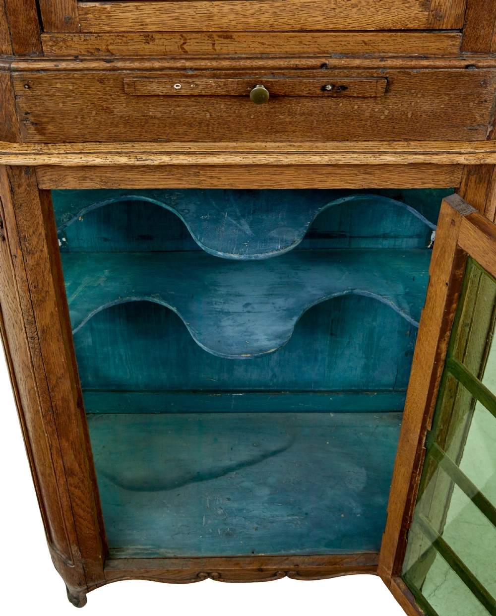 A mid-19th-century carved oak display cabinet featuring glazed doors, arched pediment, and green fabric interior lining. View X