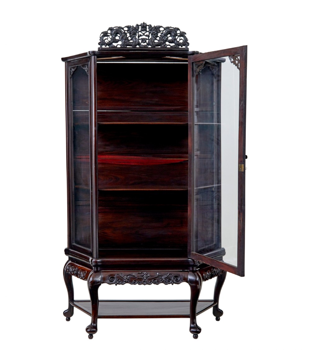 A 19th-century Chinese carved dark hardwood display cabinet featuring glazed doors, an intricate dragon cresting rail, and cabriole legs with a lower undertier. View II
