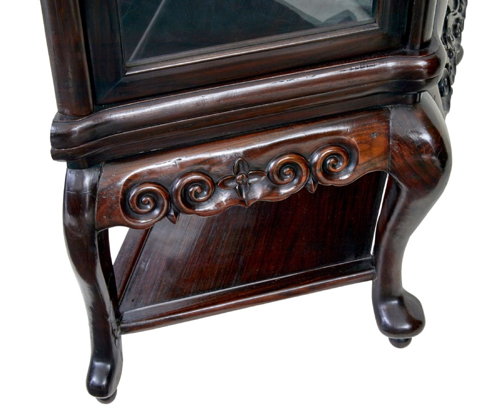 A 19th-century Chinese carved dark hardwood display cabinet featuring glazed doors, an intricate dragon cresting rail, and cabriole legs with a lower undertier. View VI