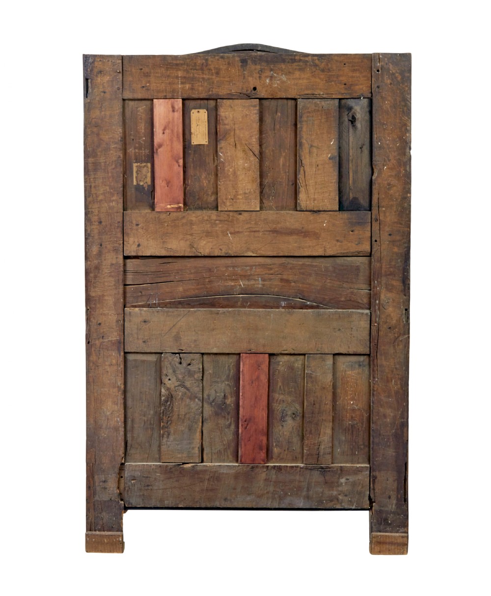 An 18th-century French armoire in warm brown yew and chestnut wood featuring carved foliate inlay, arched panel doors, and long iron escutcheons. View VI