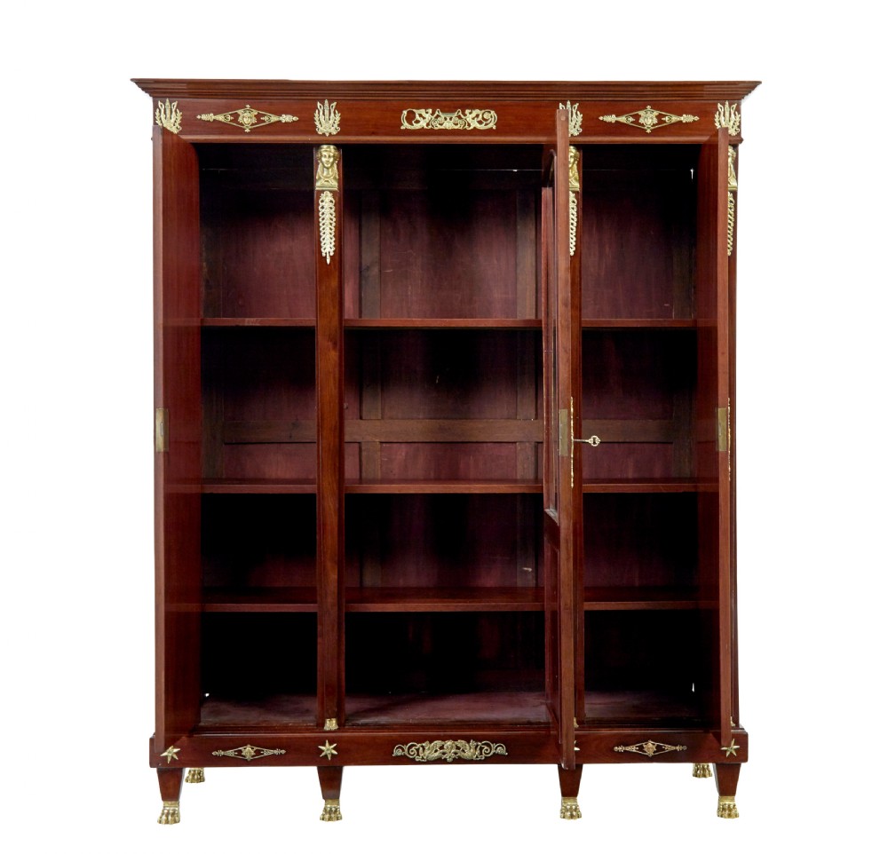 A late nineteenth-century French Empire style mahogany cabinet featuring three doors, central glass panelling, and ornate gold-coloured ormolu mounts. View III