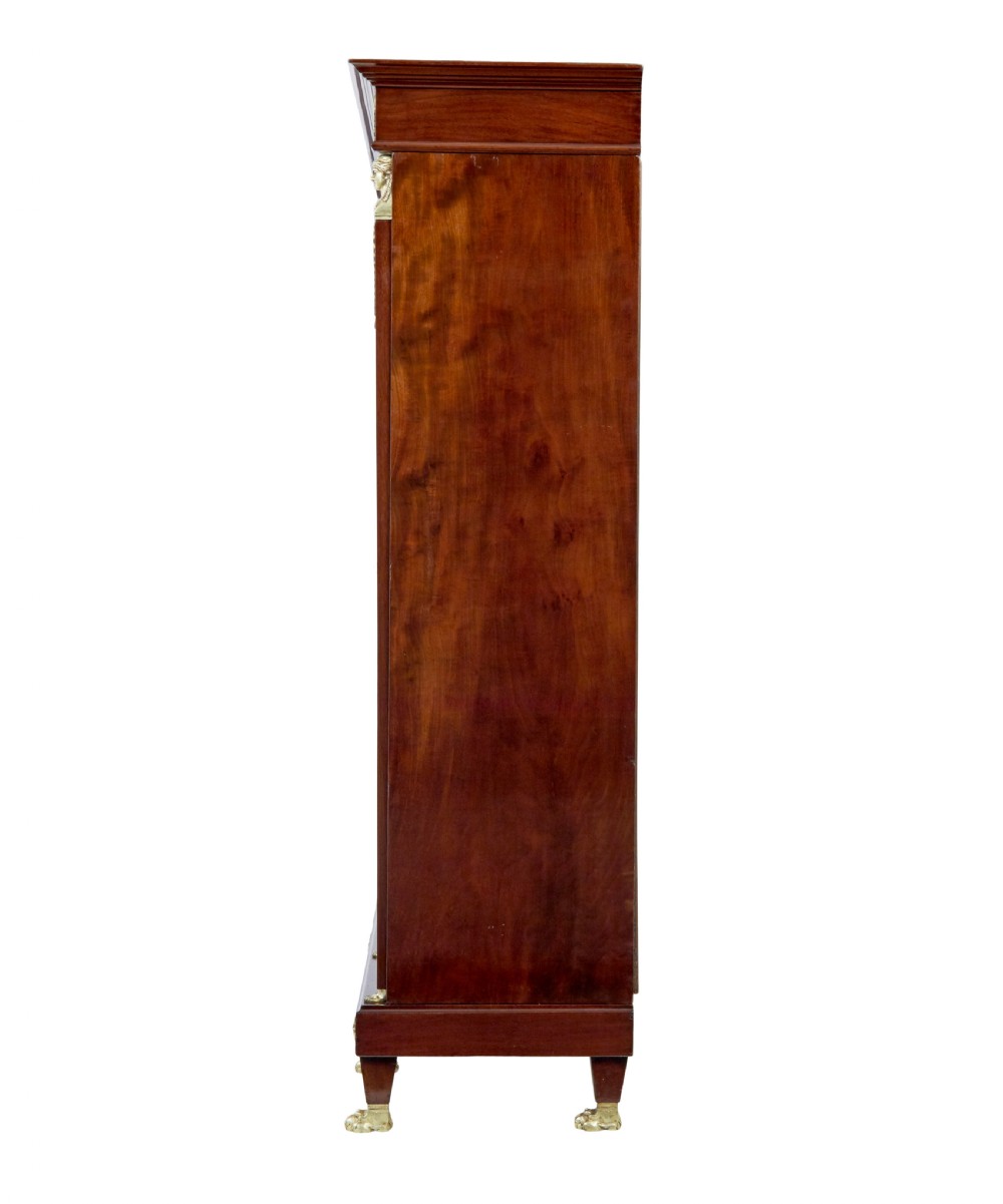 A late nineteenth-century French Empire style mahogany cabinet featuring three doors, central glass panelling, and ornate gold-coloured ormolu mounts. View VI