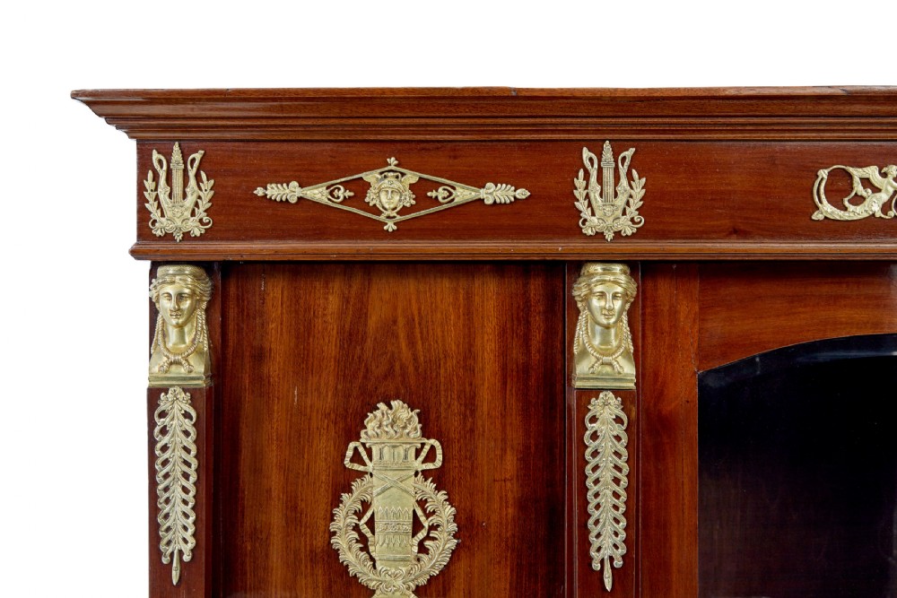 A late nineteenth-century French Empire style mahogany cabinet featuring three doors, central glass panelling, and ornate gold-coloured ormolu mounts. View VII