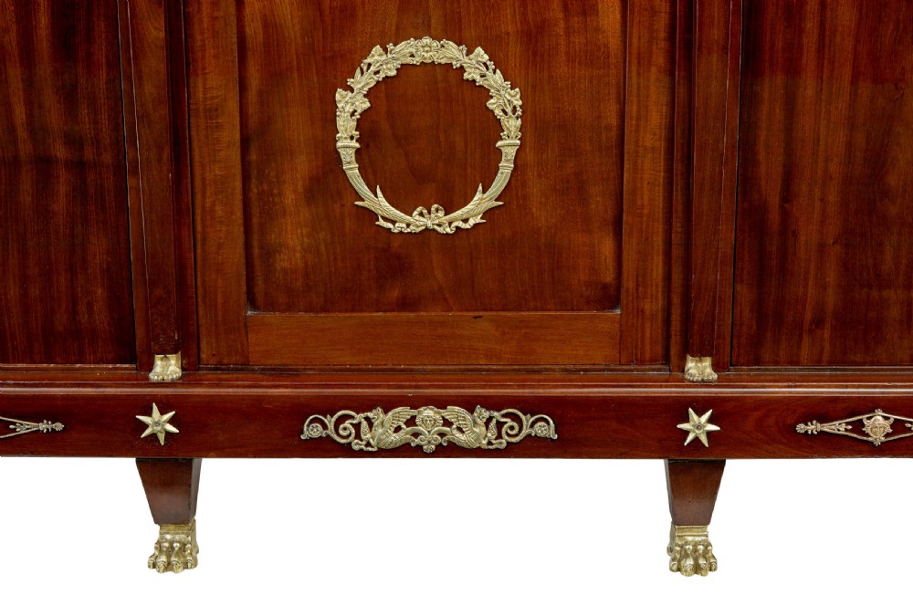 A late nineteenth-century French Empire style mahogany cabinet featuring three doors, central glass panelling, and ornate gold-coloured ormolu mounts. View IX