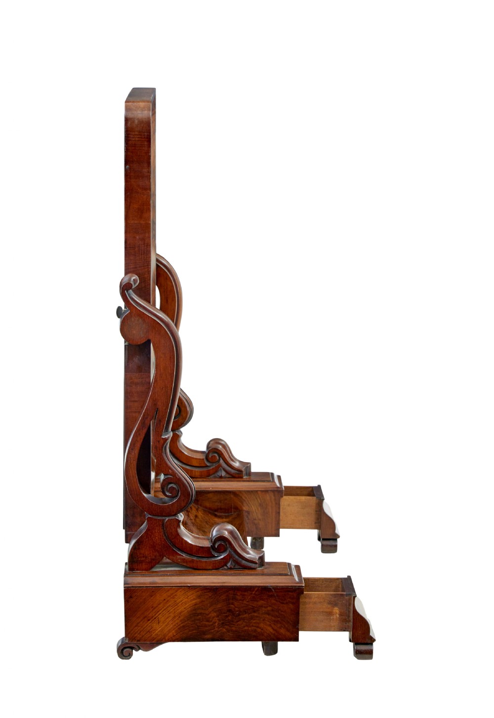 An Early Victorian mahogany toilet mirror featuring a rectangular frame set between carved scroll supports on a plinth base with scroll feet. View II