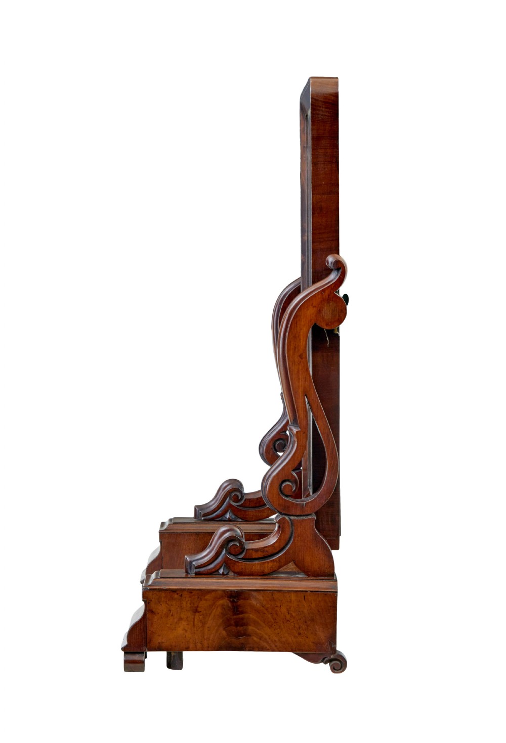 An Early Victorian mahogany toilet mirror featuring a rectangular frame set between carved scroll supports on a plinth base with scroll feet. View IV