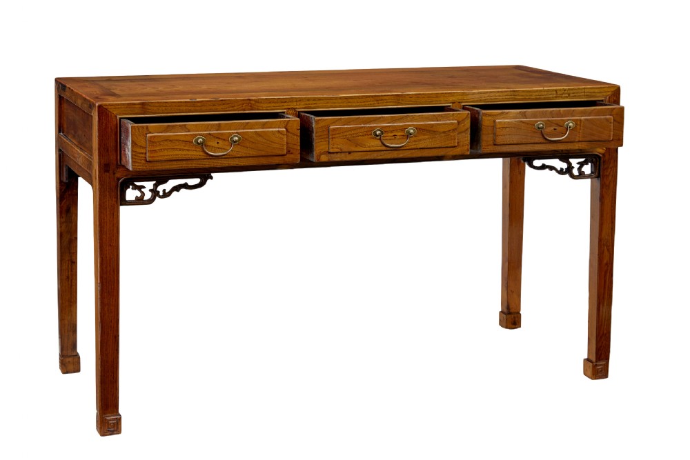 A 19th-century Chinese carved elm console table featuring three drawers with brass handles, carved corner spandrels, and square legs. View II