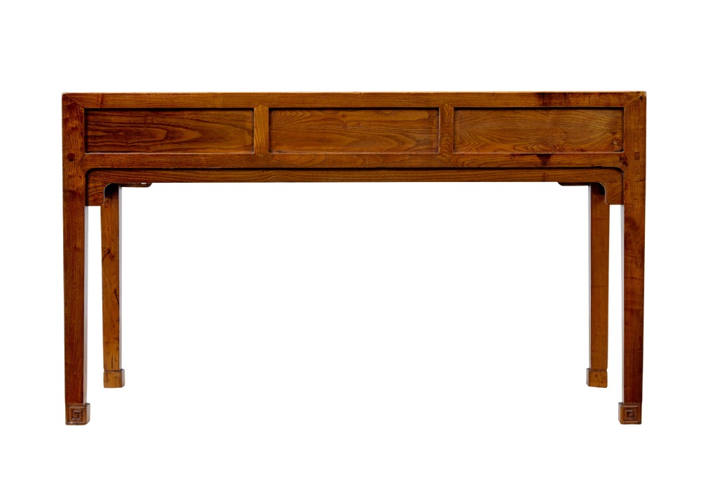 A 19th-century Chinese carved elm console table featuring three drawers with brass handles, carved corner spandrels, and square legs. View V