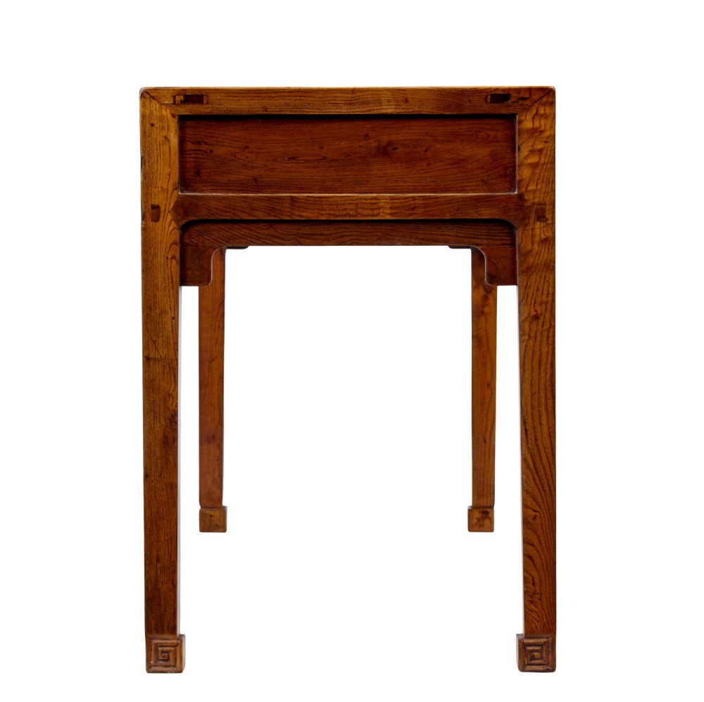 A 19th-century Chinese carved elm console table featuring three drawers with brass handles, carved corner spandrels, and square legs. View VI