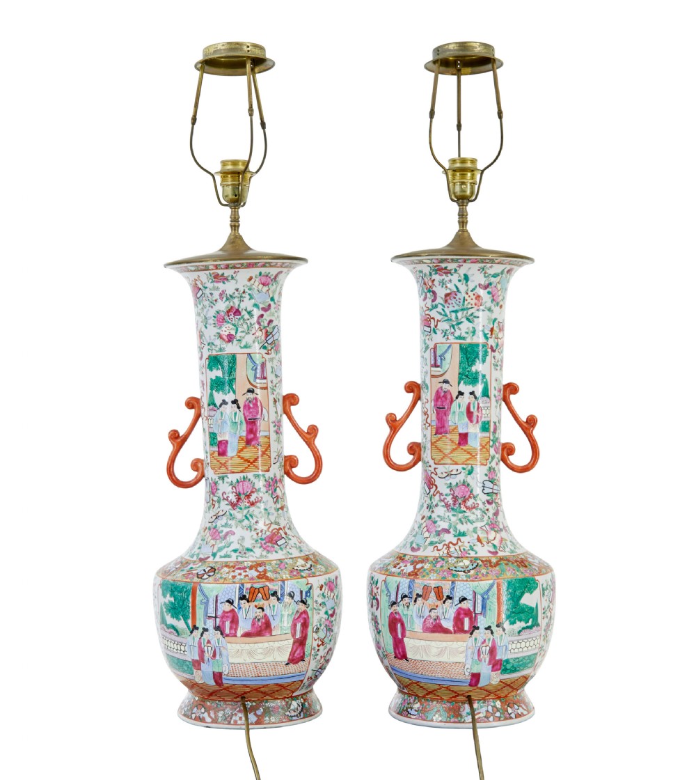 A pair of large early 20th-century Chinese Cantonese porcelain vase lamps featuring hand-painted figurative panels, scroll handles, and brass light fittings. View II