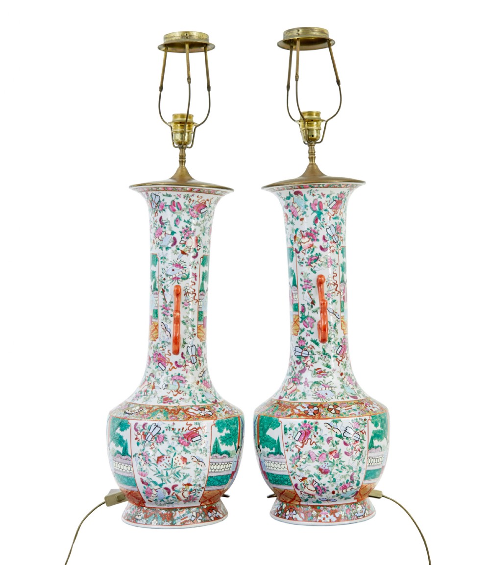 A pair of large early 20th-century Chinese Cantonese porcelain vase lamps featuring hand-painted figurative panels, scroll handles, and brass light fittings. View IV