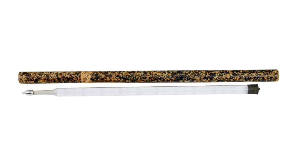 A 19th-century clear glass thermometer with printed measurement scales resting alongside its original brown marbled cylindrical paperboard storage tube. View IV