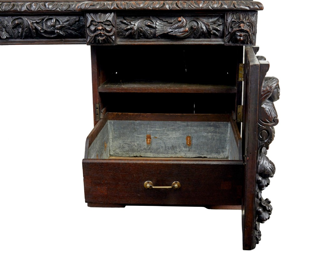 A 19th-century dark oak sideboard featuring twin carved pedestal cupboards, relief fruit swags, and an upper mirrored frame superstructure. View IV
