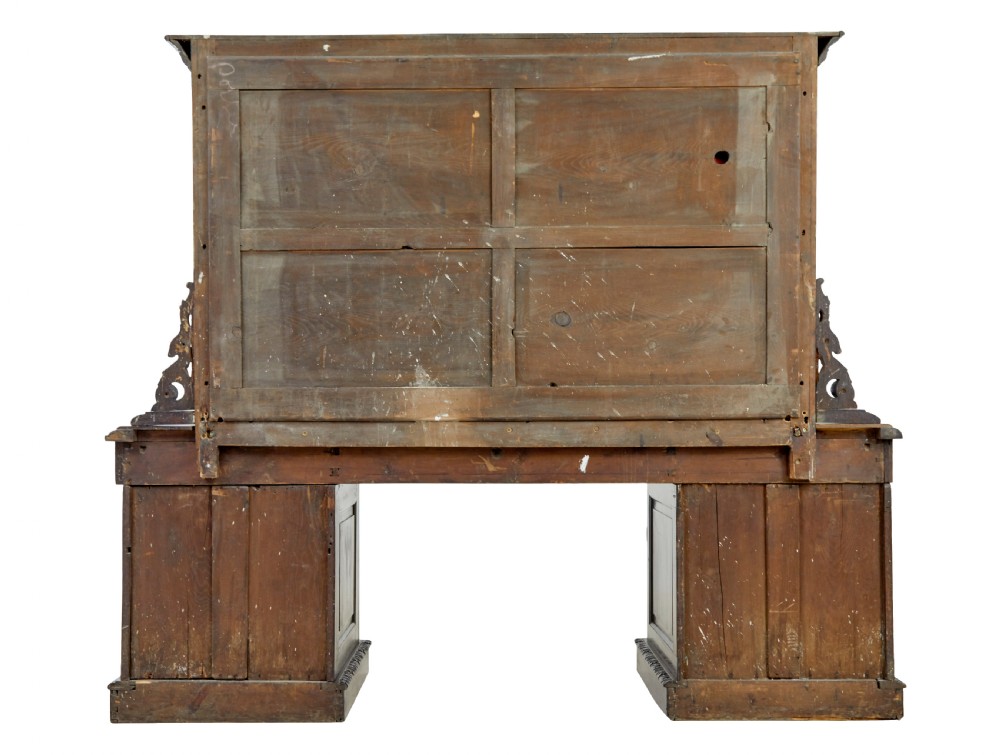 A 19th-century dark oak sideboard featuring twin carved pedestal cupboards, relief fruit swags, and an upper mirrored frame superstructure. View VIII