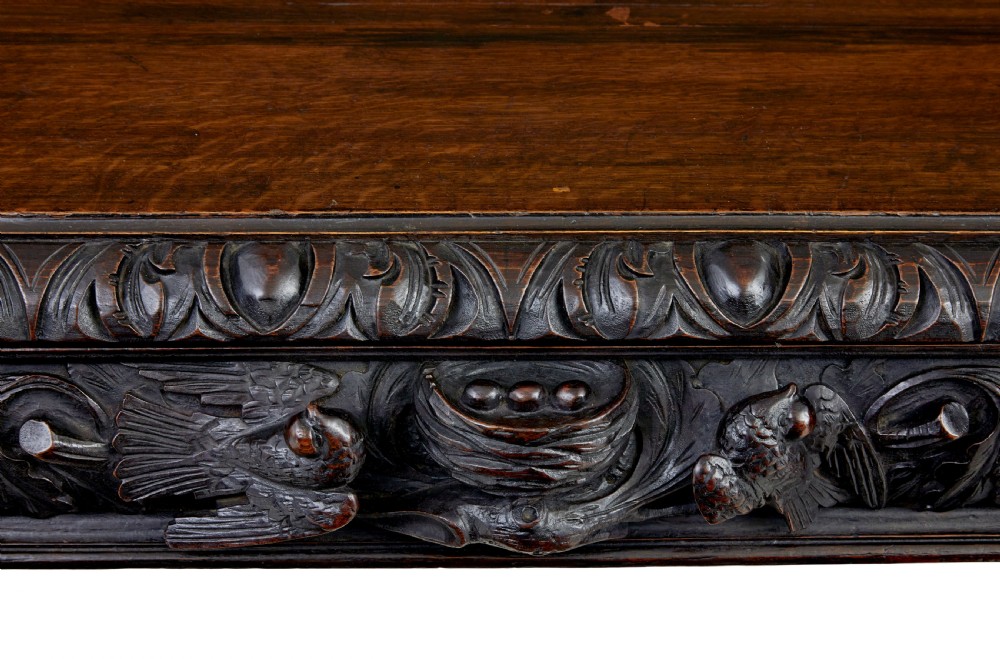 A 19th-century dark oak sideboard featuring twin carved pedestal cupboards, relief fruit swags, and an upper mirrored frame superstructure. View XII