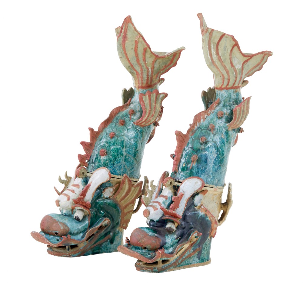 A pair of 19th-century Japanese glazed ceramic Shachihoko roof ornaments depicting dragon-headed carp with raised tails in green, red, and cream glazes.