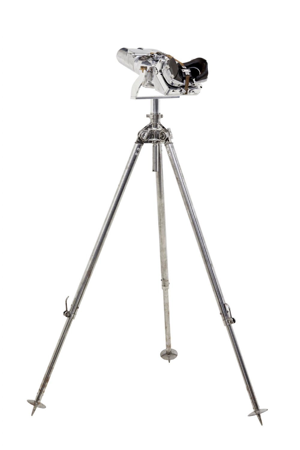 A pair of polished steel military binoculars mounted on a tall three-legged metal tripod stand against a plain background. View XIII