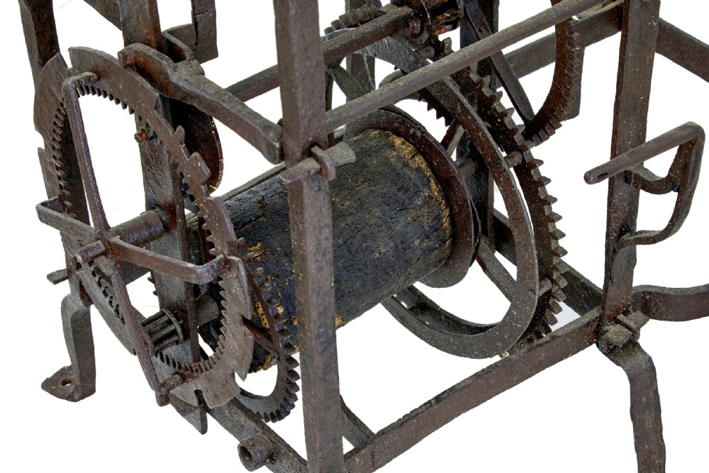 A square 18th-century Swedish copper turret clock face featuring a green verdigris patina, central sunburst motif, Roman numerals, and a single hand shaped like a pointer. View VI