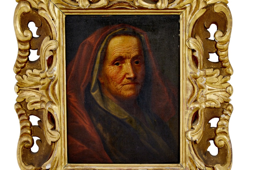 An 18th-century oil portrait depicting an elderly woman with a red hood, housed in a heavily carved gold gilt frame. View II