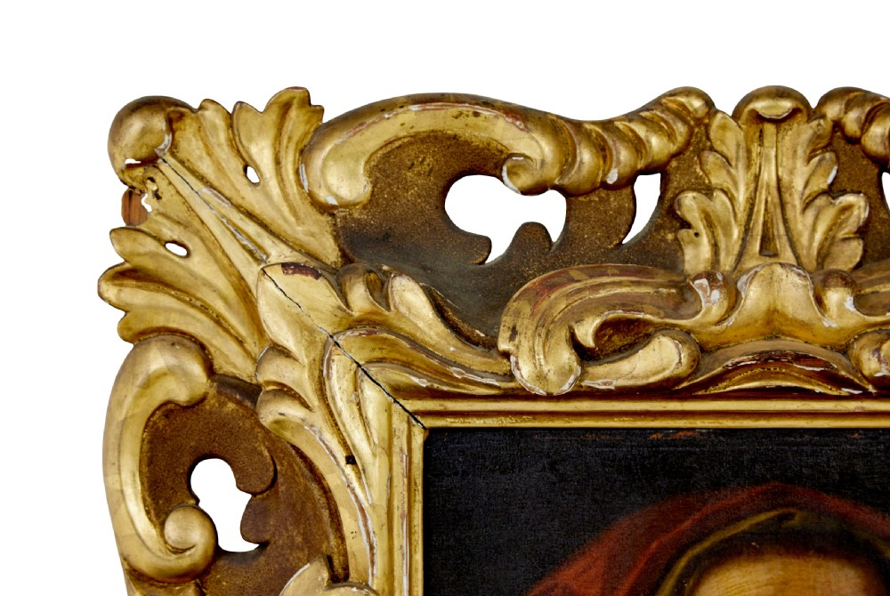 An 18th-century oil portrait depicting an elderly woman with a red hood, housed in a heavily carved gold gilt frame. View IV