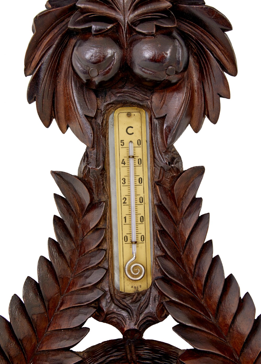 A 19th-century dark carved walnut aneroid wall barometer featuring foliate leaf carvings surrounding a central thermometer tube and a lower circular glass dial. View V