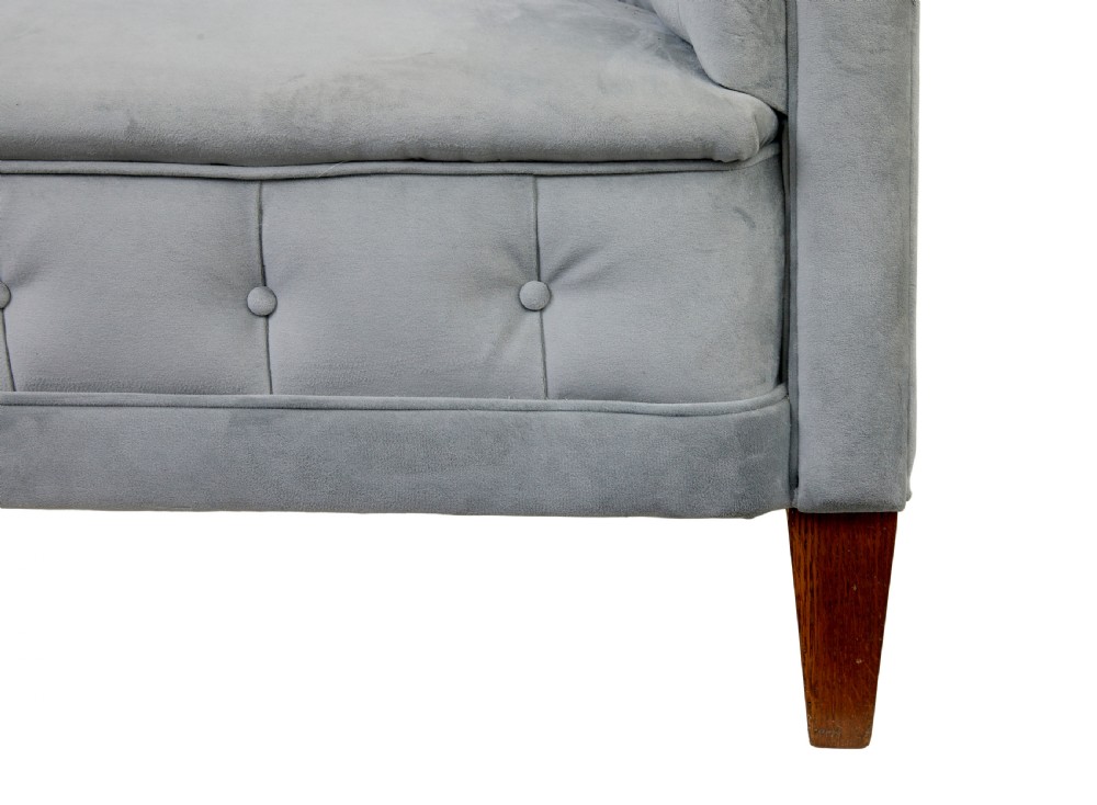 An early 20th-century three-piece suite comprising a two-seater sofa and two matching armchairs upholstered in light grey deep-buttoned velvet with tapered wooden legs. View IX