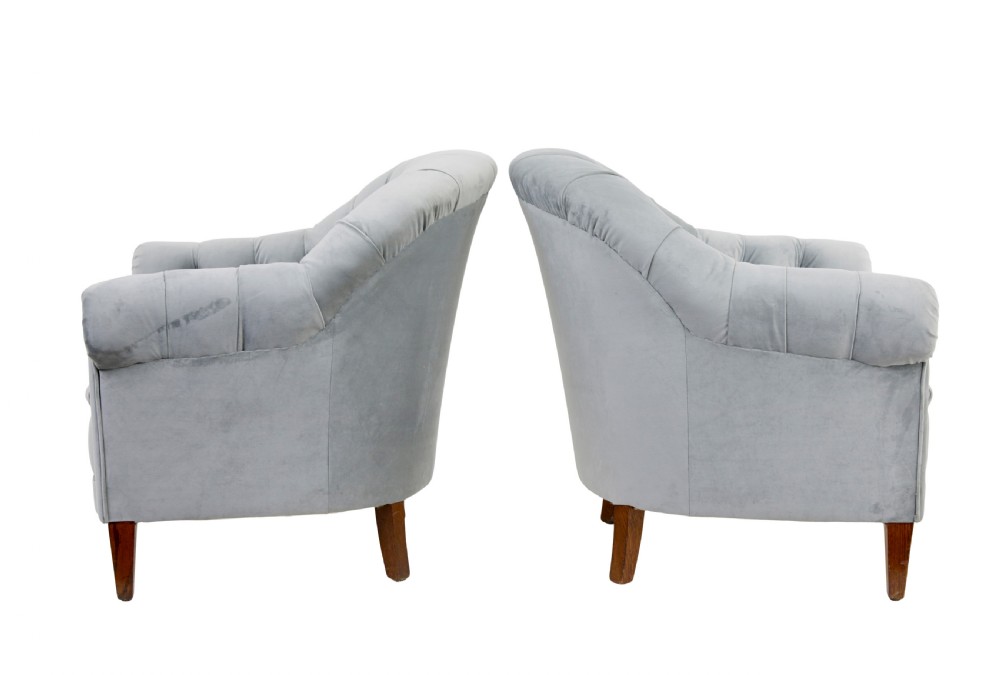 An early 20th-century three-piece suite comprising a two-seater sofa and two matching armchairs upholstered in light grey deep-buttoned velvet with tapered wooden legs. View XI