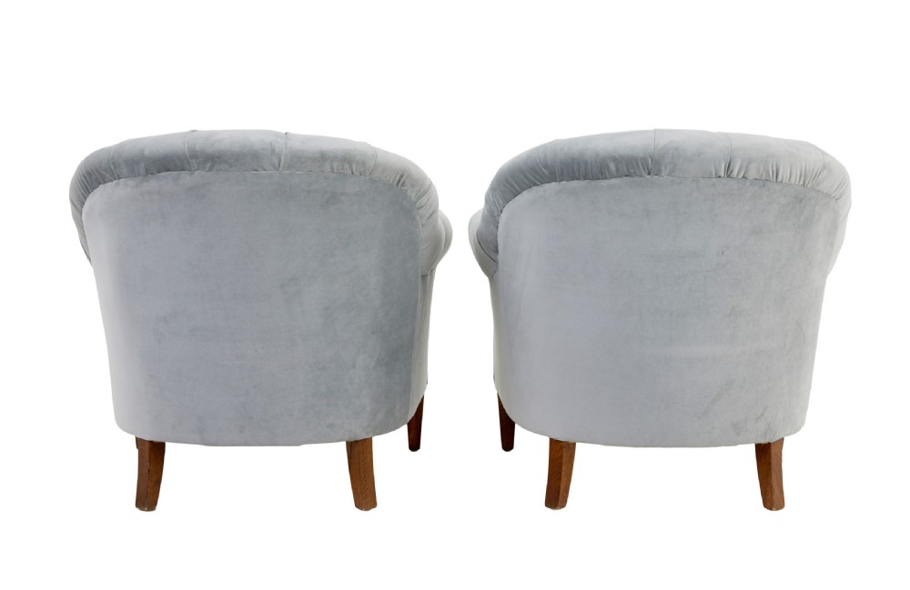 An early 20th-century three-piece suite comprising a two-seater sofa and two matching armchairs upholstered in light grey deep-buttoned velvet with tapered wooden legs. View XII