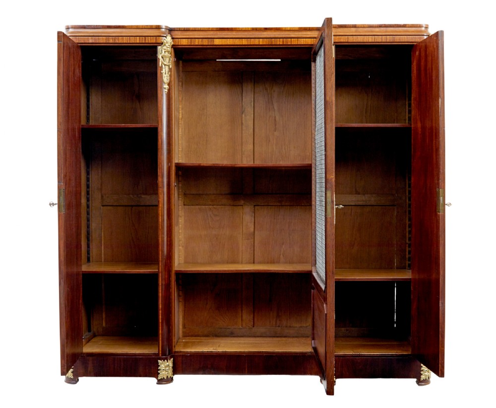 A nineteenth-century French Empire style mahogany cabinet featuring decorative ormolu mounts, a central brass wire mesh door, and outer panelled doors with shell inlays. View III