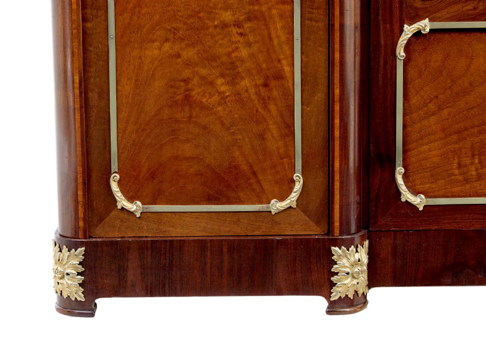 A nineteenth-century French Empire style mahogany cabinet featuring decorative ormolu mounts, a central brass wire mesh door, and outer panelled doors with shell inlays. View VII