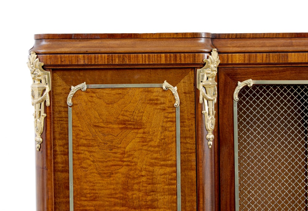 A nineteenth-century French Empire style mahogany cabinet featuring decorative ormolu mounts, a central brass wire mesh door, and outer panelled doors with shell inlays. View VIII