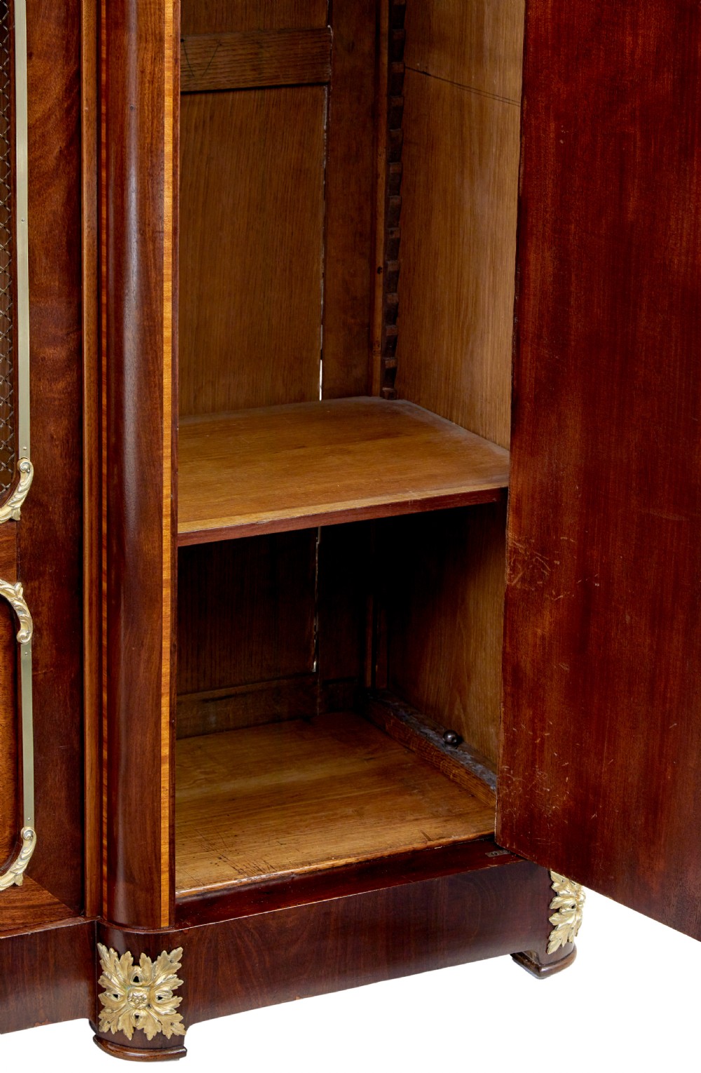 A nineteenth-century French Empire style mahogany cabinet featuring decorative ormolu mounts, a central brass wire mesh door, and outer panelled doors with shell inlays. View IX