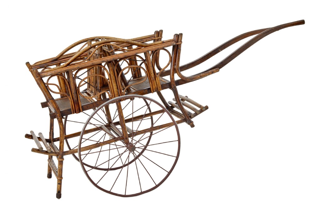 An early 20th-century oriental child carriage constructed from bent warm brown bamboo with two seats and large metal spoked wheels.